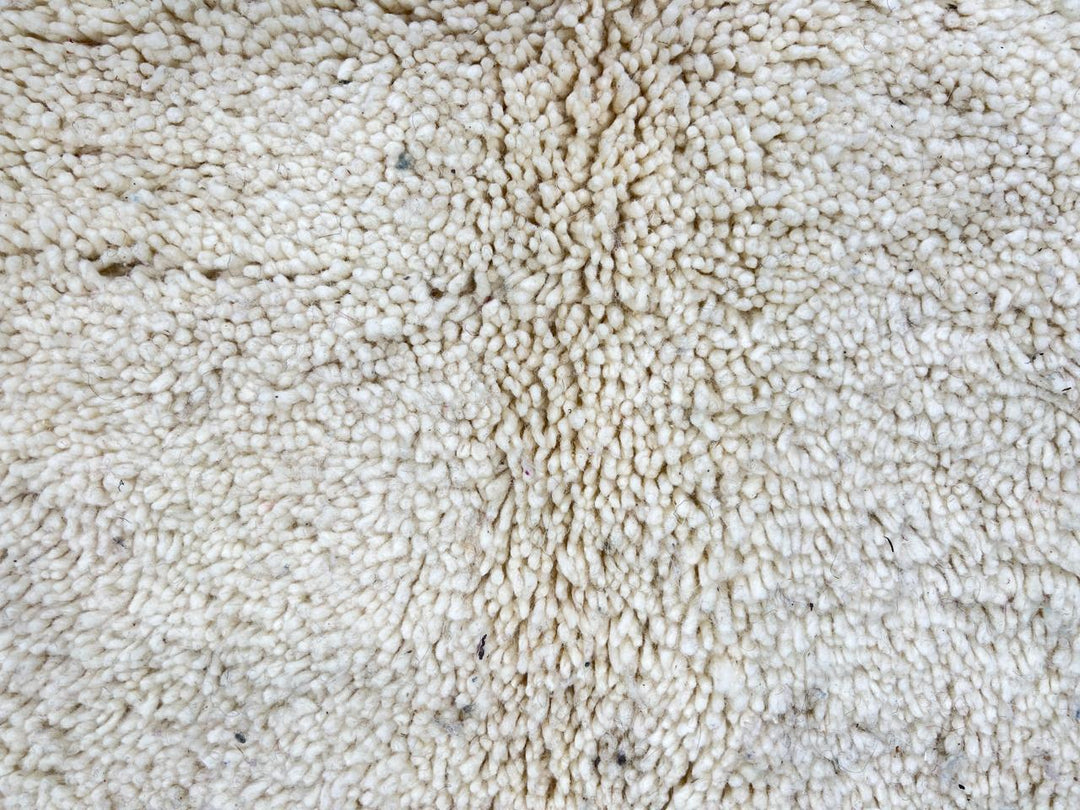 Handmade Moroccan wool rug with abstract Berber-inspired design, earthy tones, and round shape.