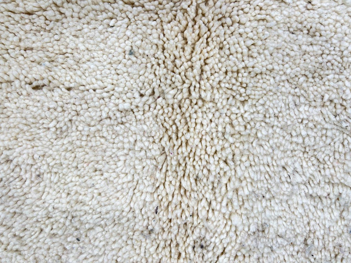 Handmade Moroccan wool rug with abstract Berber-inspired design, earthy tones, and round shape.