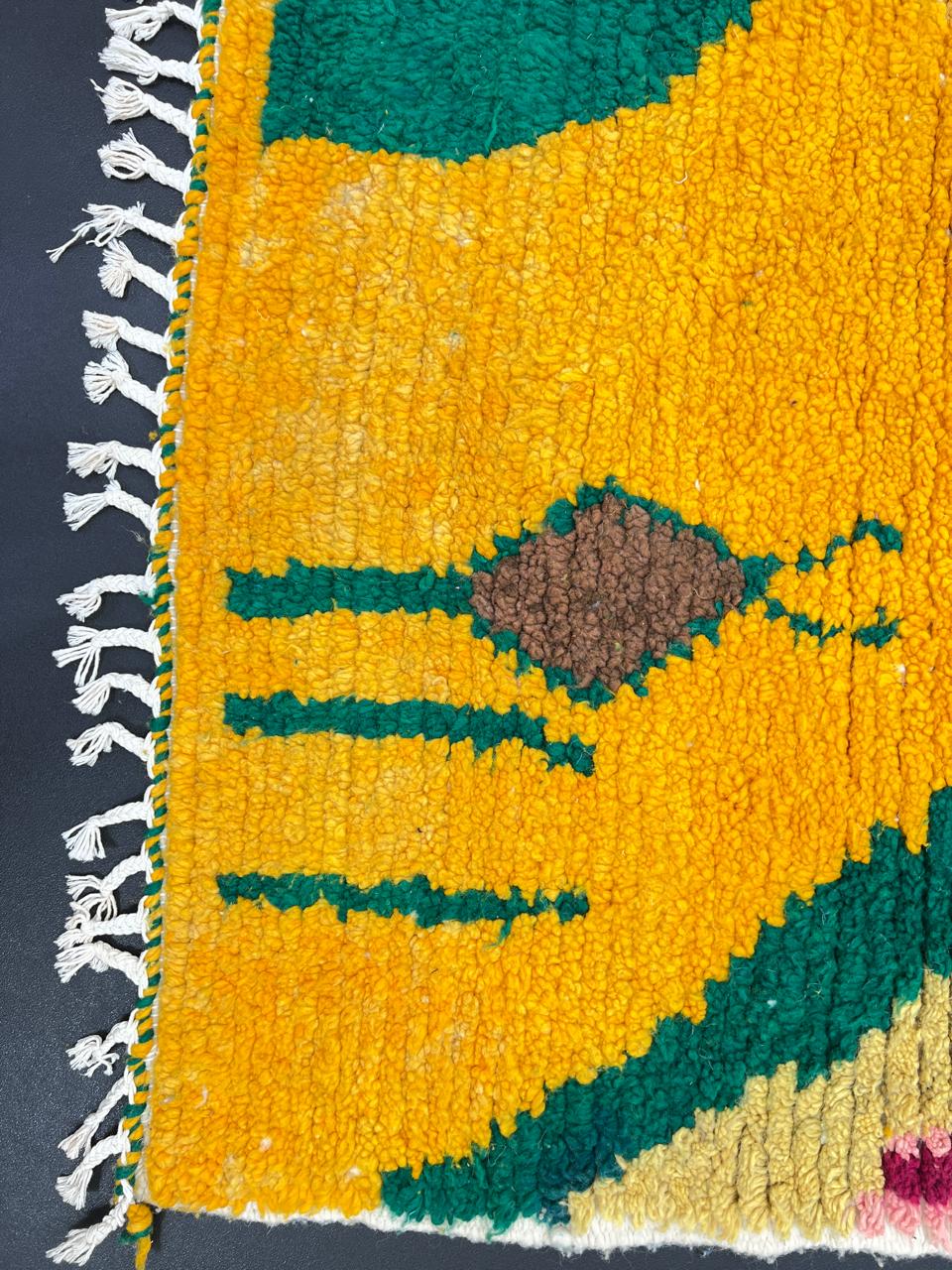 Handmade Moroccan runner rug with colorful abstract village-inspired motifs in mustard, teal, pink, black, and cream, crafted from natural wool.