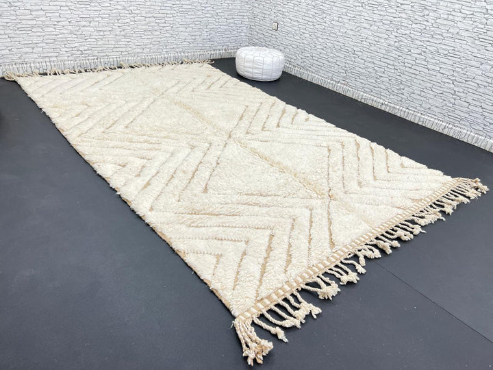 Handmade beige Moroccan wool rug with chevron geometric pattern, soft plush texture