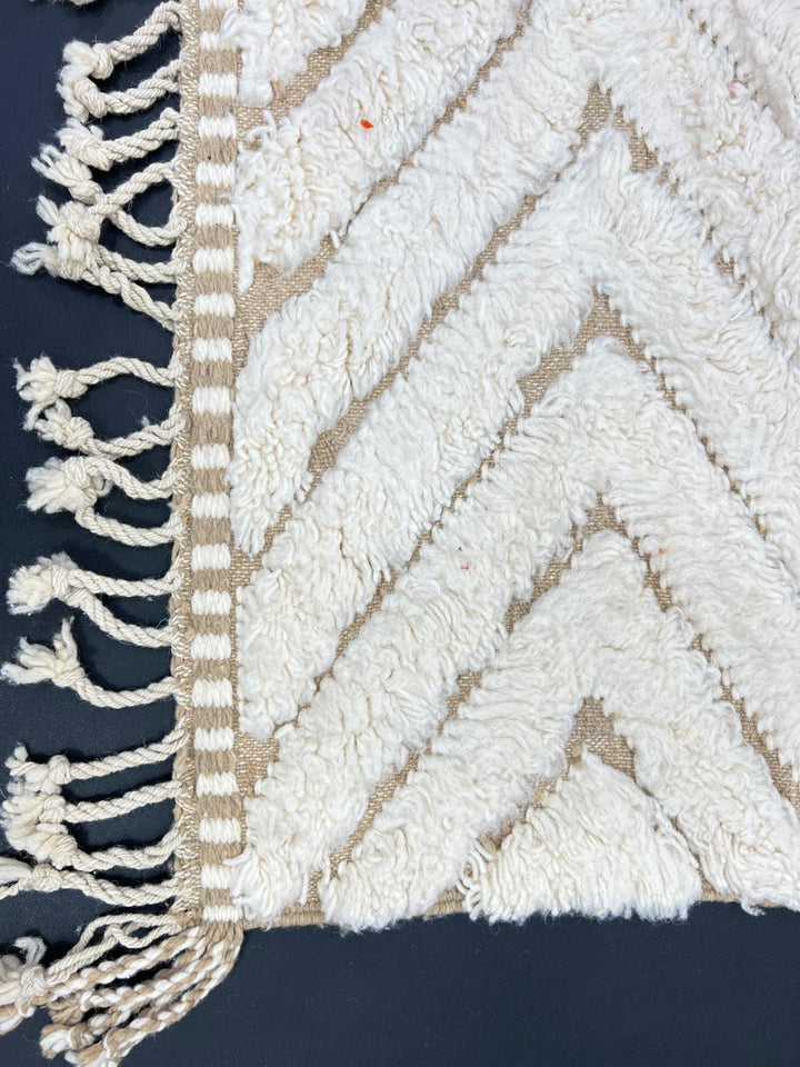 Handmade beige Moroccan wool rug with chevron geometric pattern, soft plush texture