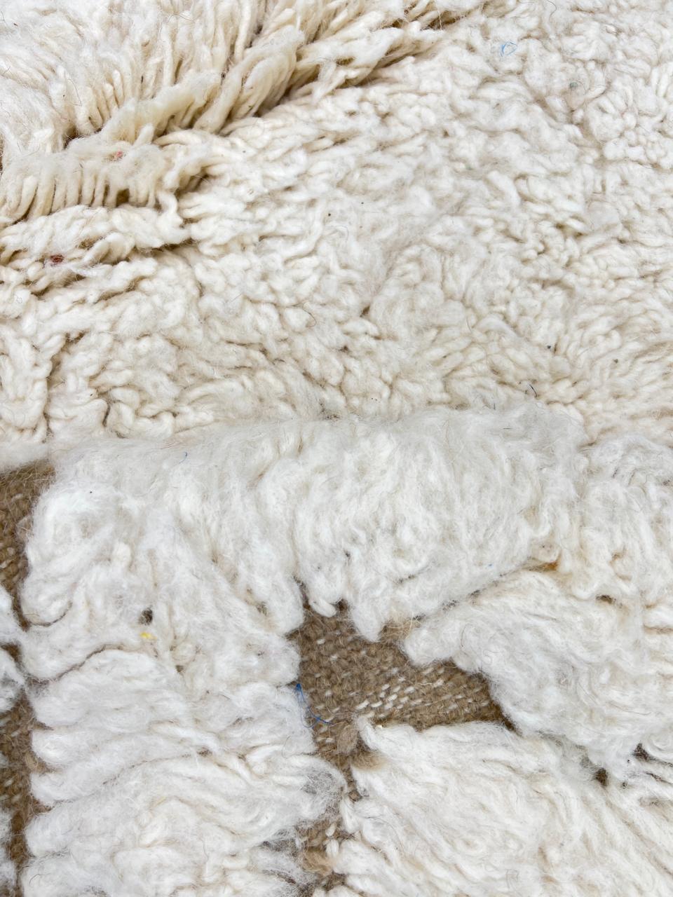 Handmade beige Moroccan wool rug with chevron geometric pattern, soft plush texture