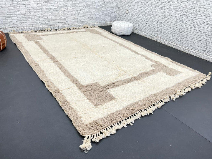 Beige minimalist Moroccan wool rug with geometric border pattern