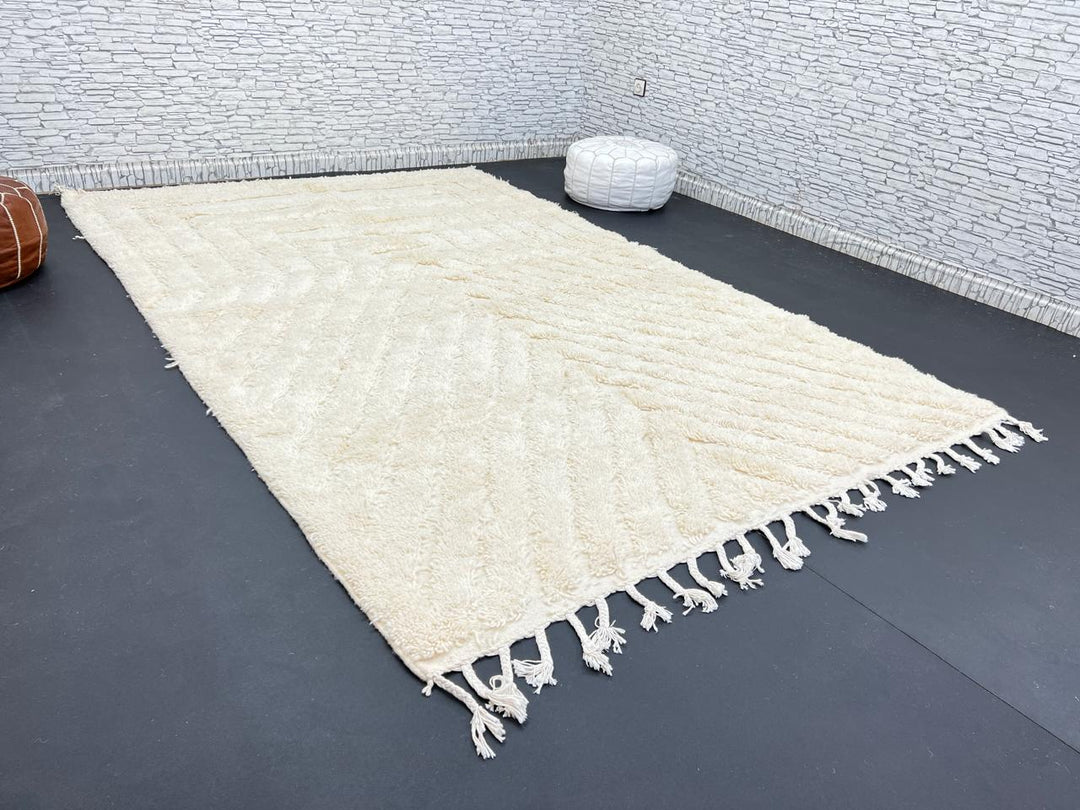 Handwoven beige Moroccan wool rug with minimalist geometric carved pattern