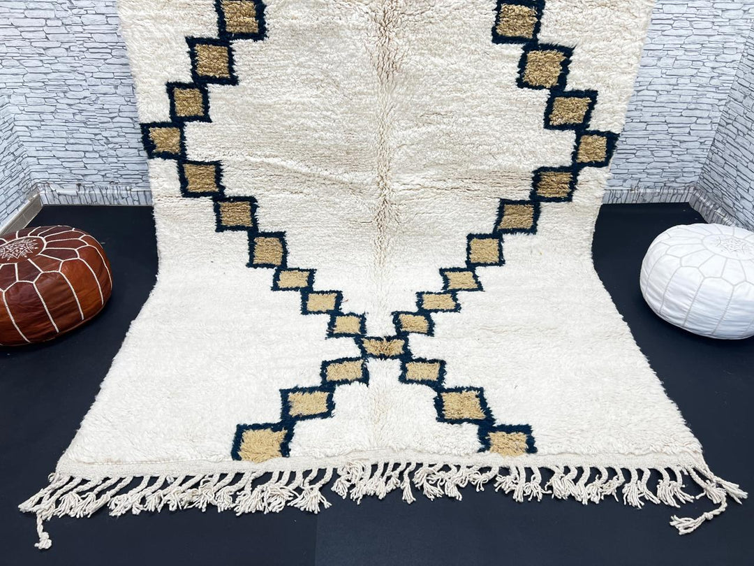Beige Moroccan wool rug with black geometric diamond pattern, handmade by Berber artisans
