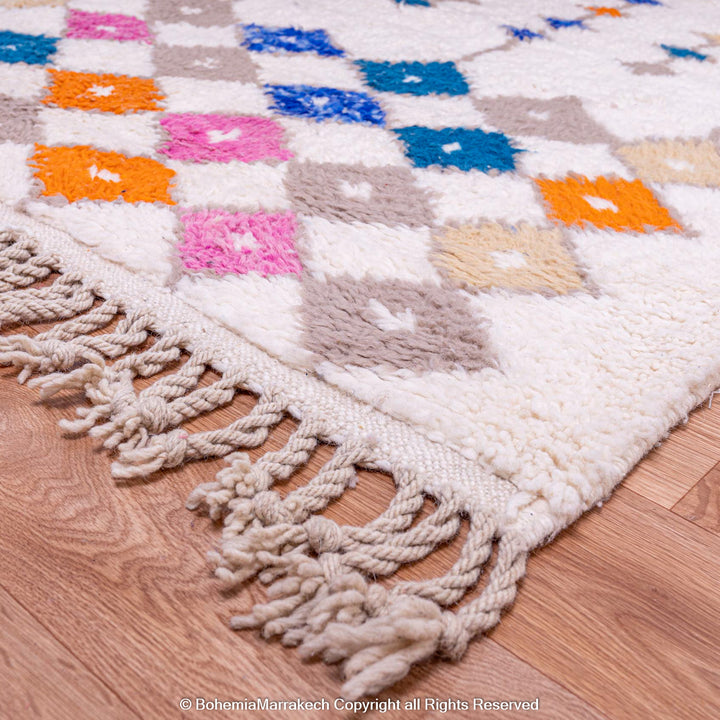 Handmade Moroccan rug with colorful diamond pattern on ivory wool background