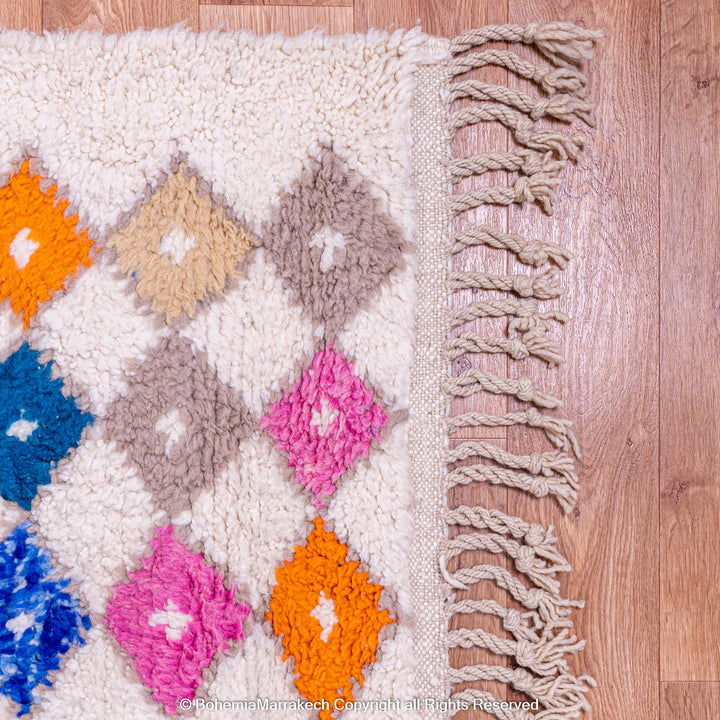 Handmade Moroccan rug with colorful diamond pattern on ivory wool background