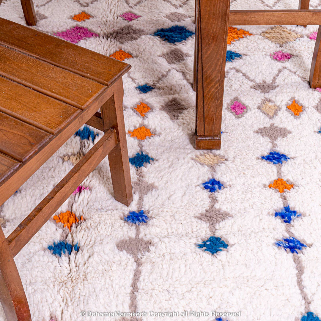 Handmade Moroccan rug with colorful diamond pattern on ivory wool background