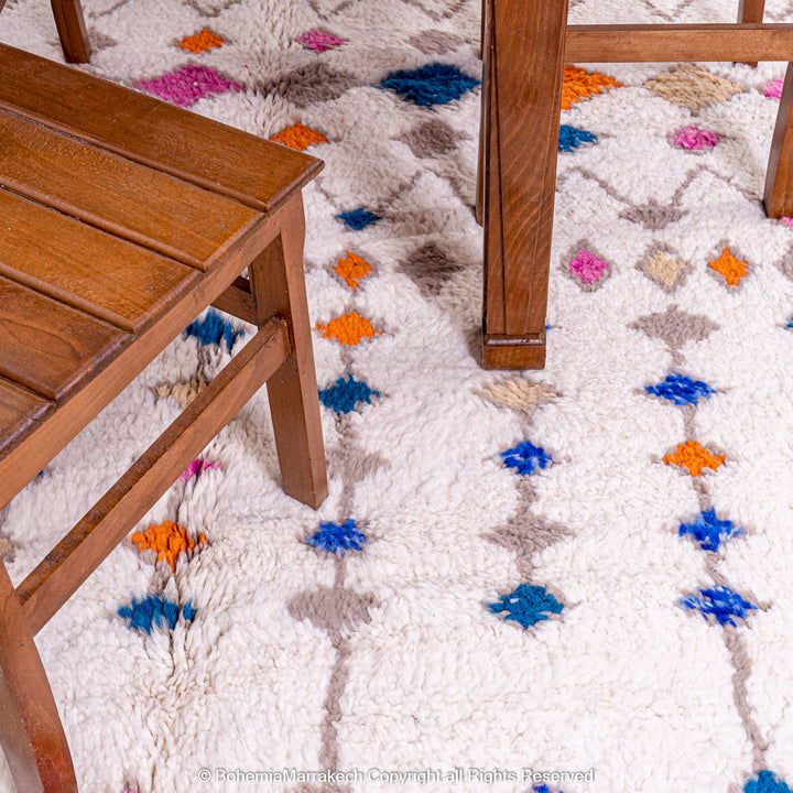 Handmade Moroccan rug with colorful diamond pattern on ivory wool background
