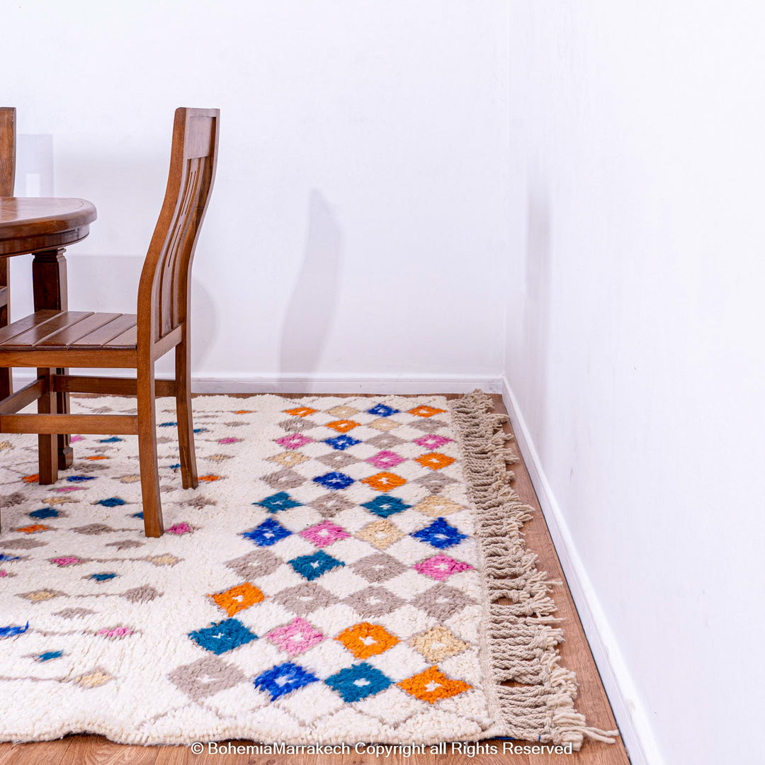 Handmade Moroccan rug with colorful diamond pattern on ivory wool background