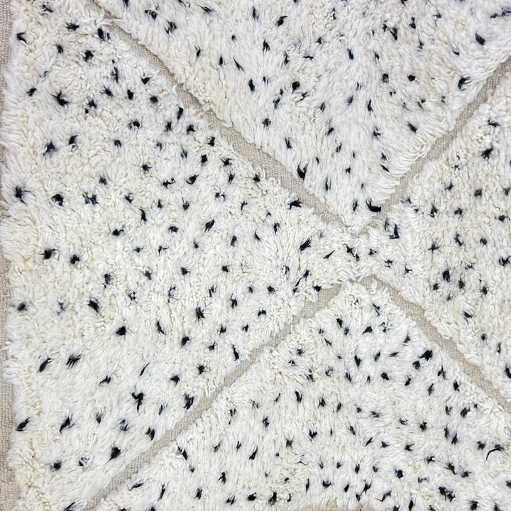 Handmade Moroccan wool rug with ivory base, diamond Berber pattern and subtle speckled accents. Soft plush texture, artisan crafted.