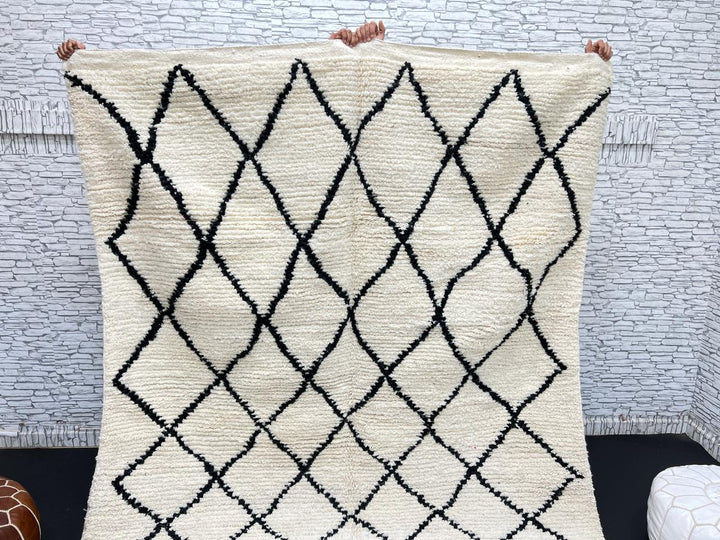 Handwoven Beni Ourain Moroccan wool rug with black diamond pattern on ivory background