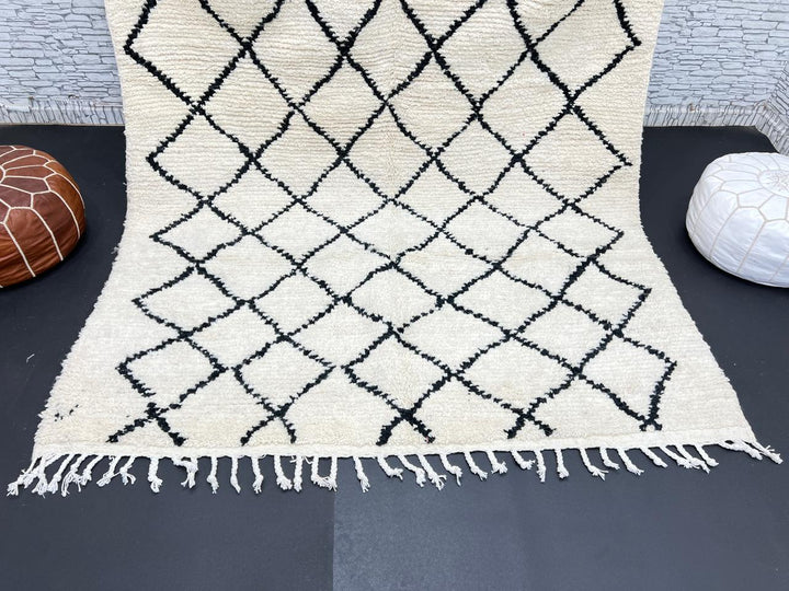 Handwoven Beni Ourain Moroccan wool rug with black diamond pattern on ivory background