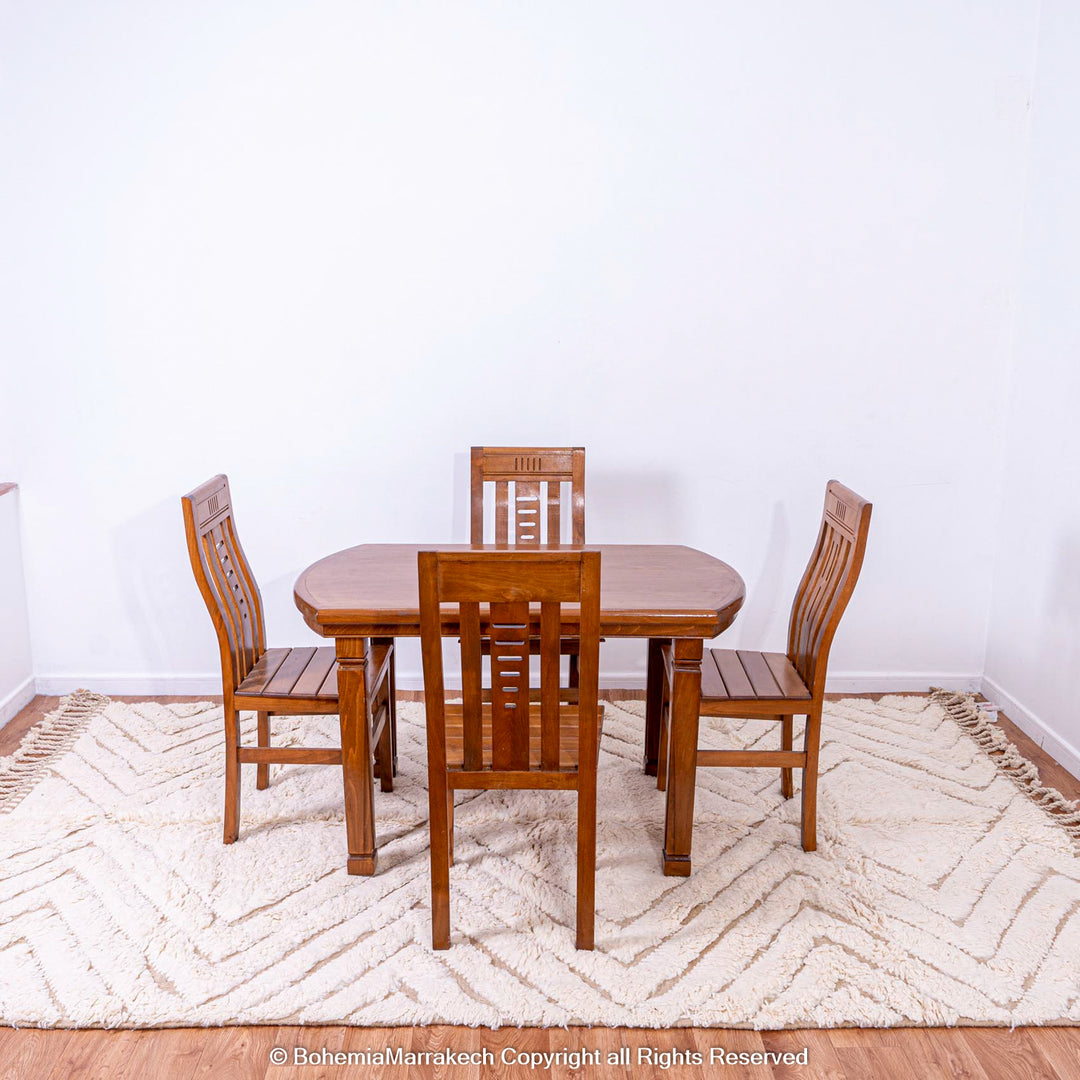 Handmade Beni Ourain Moroccan wool rug under wooden dining set in minimalist room.