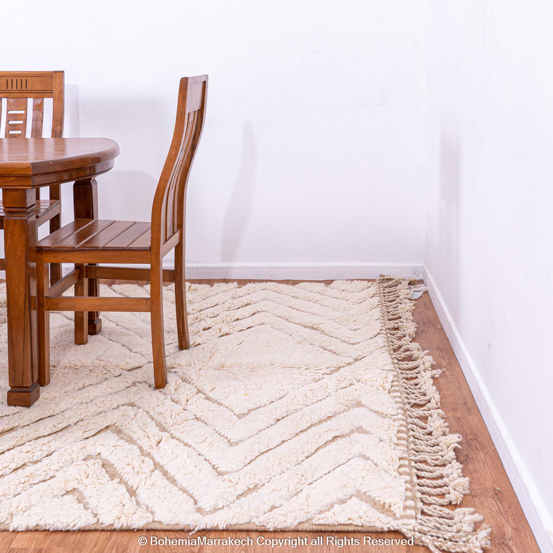 Handwoven Beni Ourain Moroccan wool rug with geometric zigzag pattern under dining table.