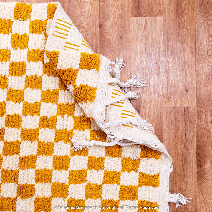 Handwoven Moroccan rug in yellow and white checkerboard pattern, crafted from soft wool