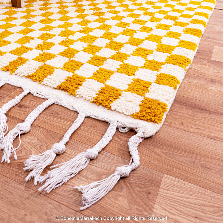 Handwoven Moroccan rug in yellow and white checkerboard pattern, crafted from soft wool