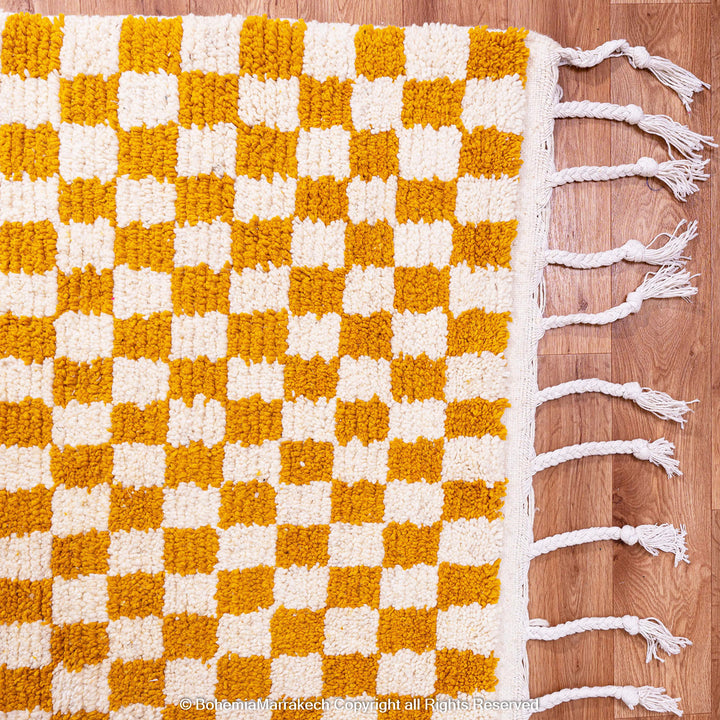 Handwoven Moroccan rug in yellow and white checkerboard pattern, crafted from soft wool