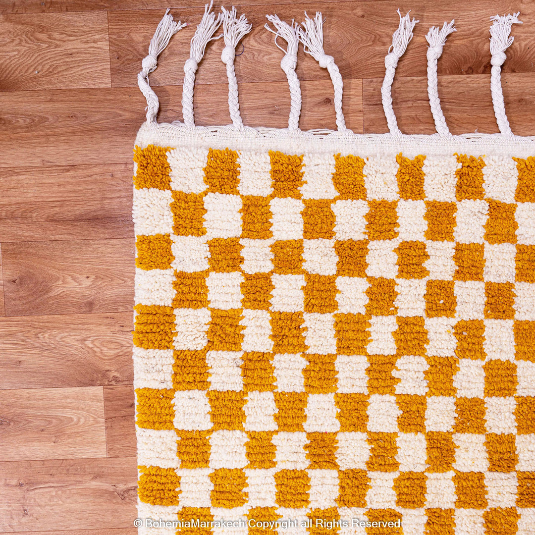 Handwoven Moroccan rug in yellow and white checkerboard pattern, crafted from soft wool