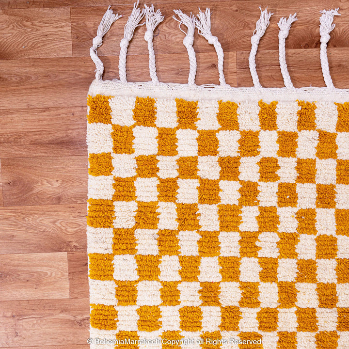 Handwoven Moroccan rug in yellow and white checkerboard pattern, crafted from soft wool