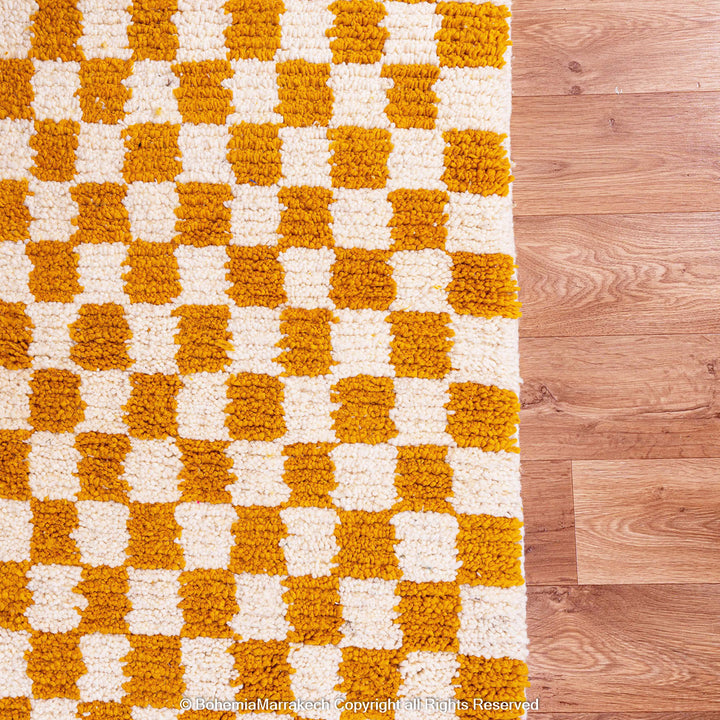 Handwoven Moroccan rug in yellow and white checkerboard pattern, crafted from soft wool