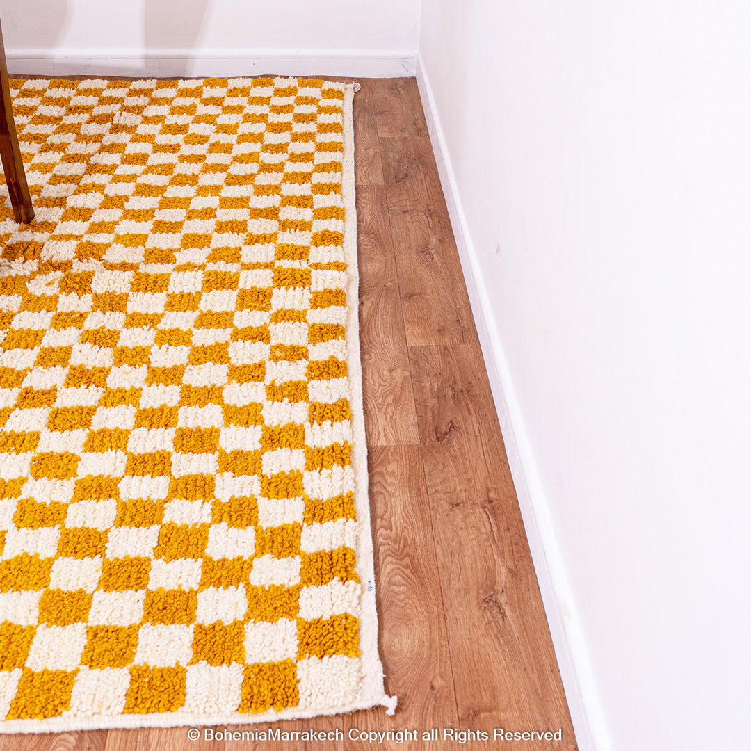 Handwoven Moroccan rug in yellow and white checkerboard pattern, crafted from soft wool