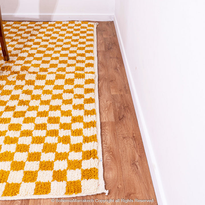 Handwoven Moroccan rug in yellow and white checkerboard pattern, crafted from soft wool