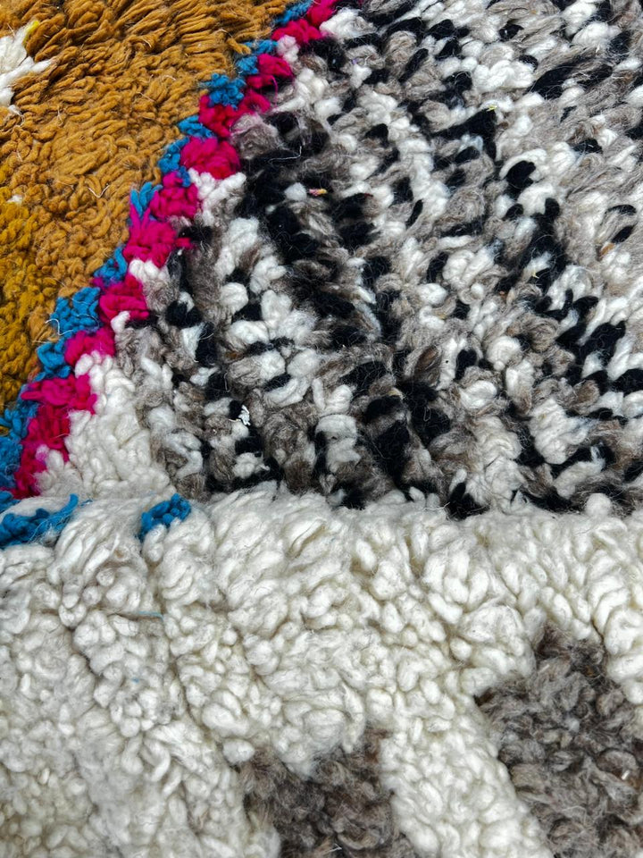 Handmade round Moroccan wool rug with traditional Berber symbols and tribal patterns on white background