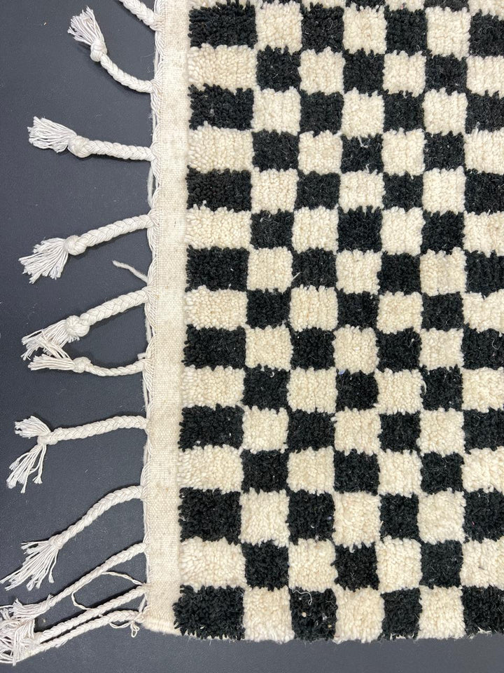 Handmade black and white checkered Moroccan runner rug crafted from natural wool.