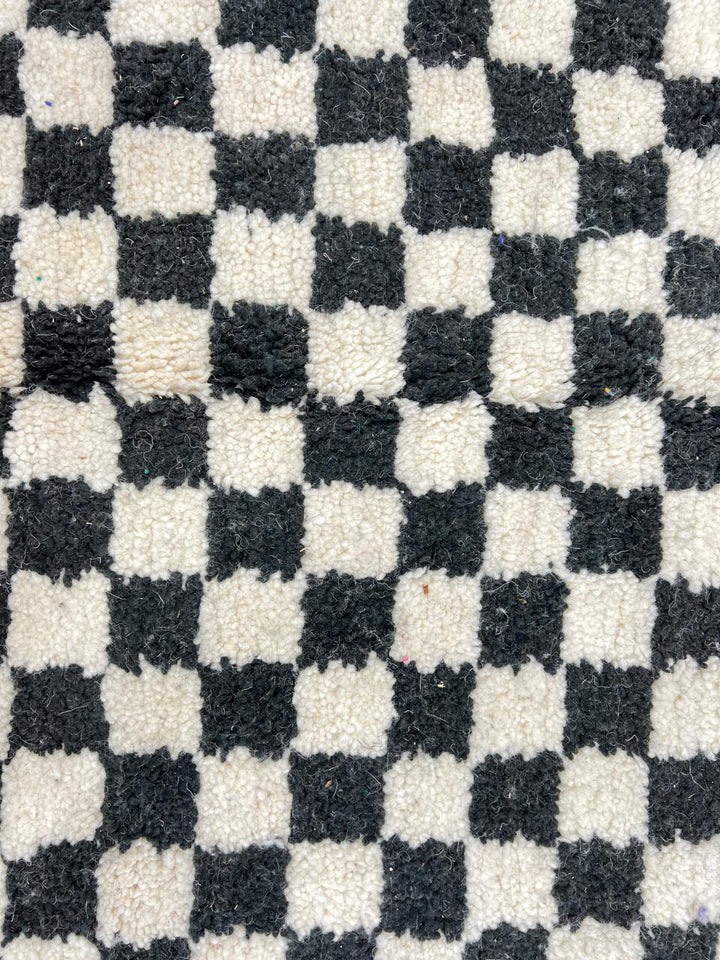 Handmade black and white checkered Moroccan runner rug crafted from natural wool.