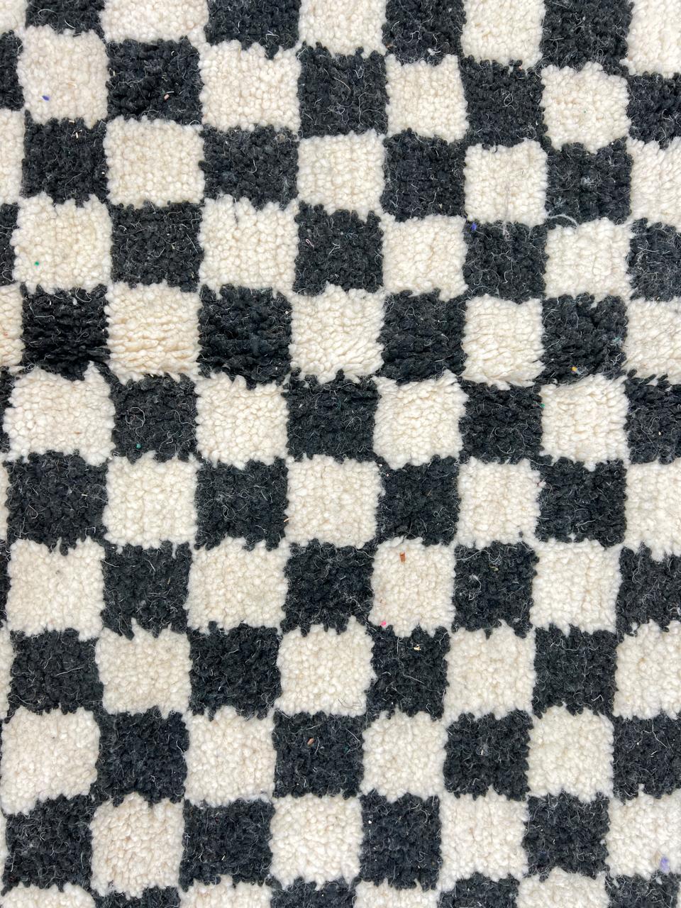 Handmade black and white checkered Moroccan runner rug crafted from natural wool.