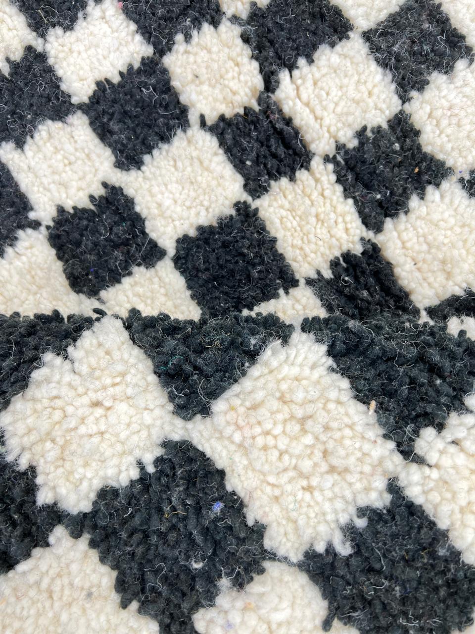 Handmade black and white checkered Moroccan runner rug crafted from natural wool.