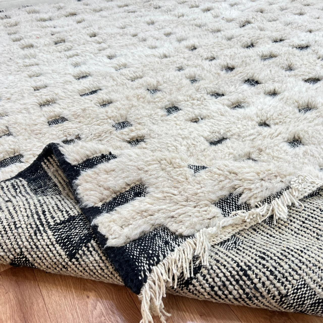 Handmade Moroccan wool rug with ivory base and subtle black square grid. Soft plush texture, minimalist style, artisan crafted.