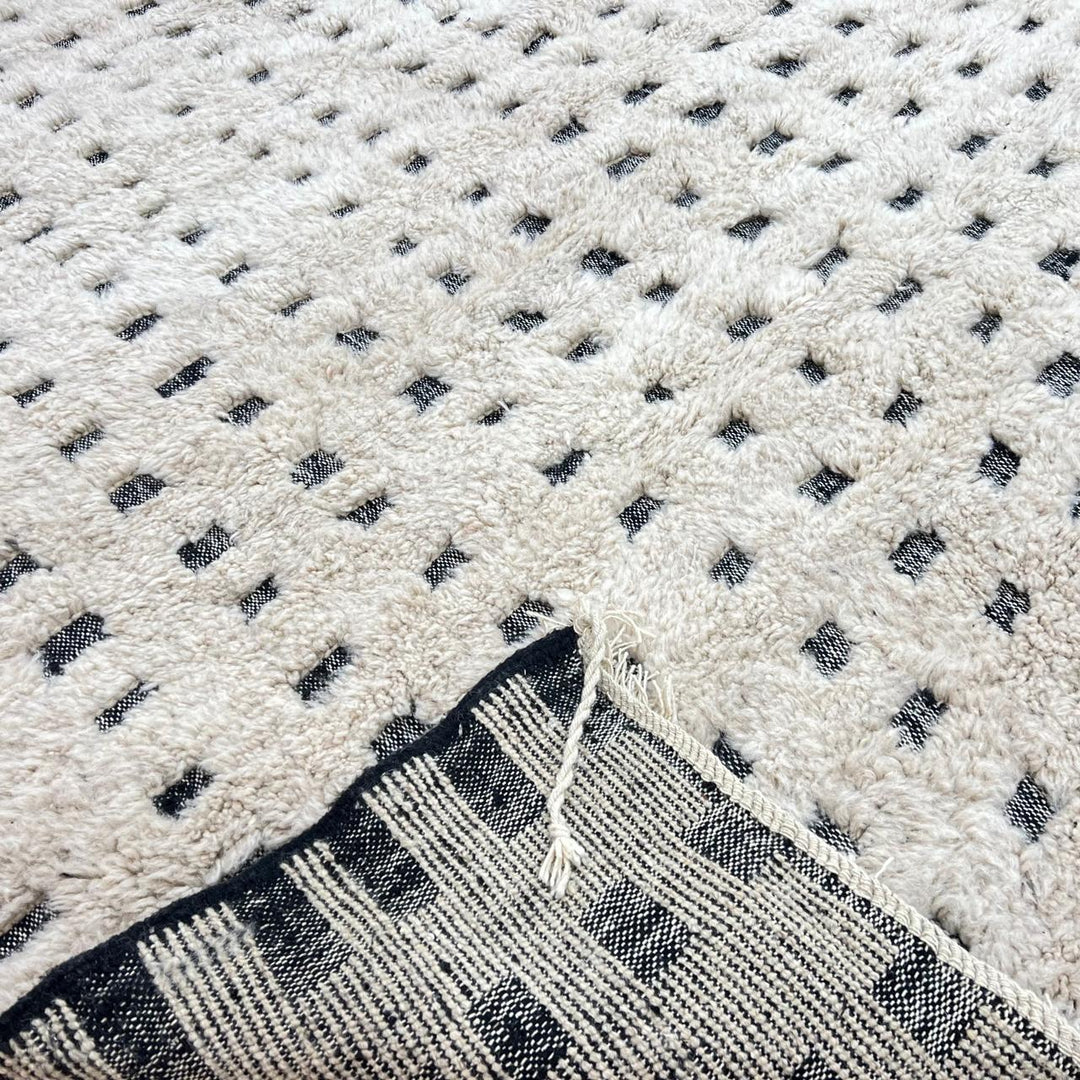 Handmade Moroccan wool rug with ivory base and subtle black square grid. Soft plush texture, minimalist style, artisan crafted.
