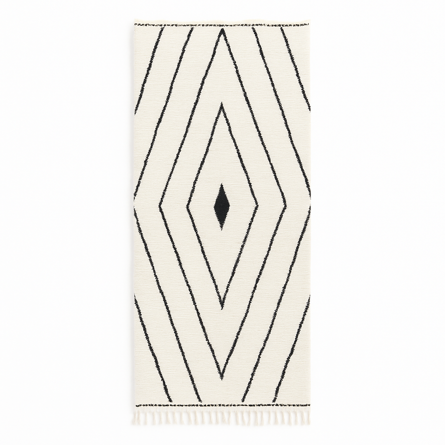 Handmade Moroccan runner rug with black geometric diamond pattern on a white wool background.