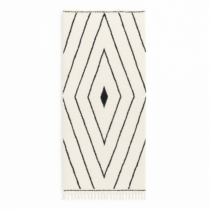 Handmade Moroccan runner rug with black geometric diamond pattern on a white wool background.