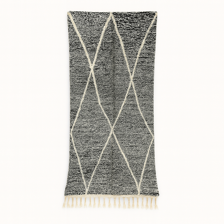 Black and white Moroccan wool runner rug with geometric diamond pattern and tassels, handmade by Berber artisans