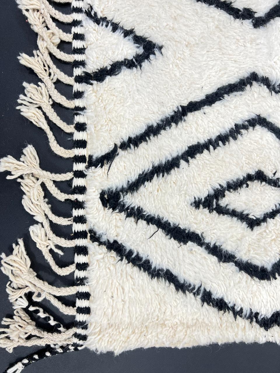 Black and white Moroccan wool runner rug with Beni Ourain diamond pattern and fringed edges