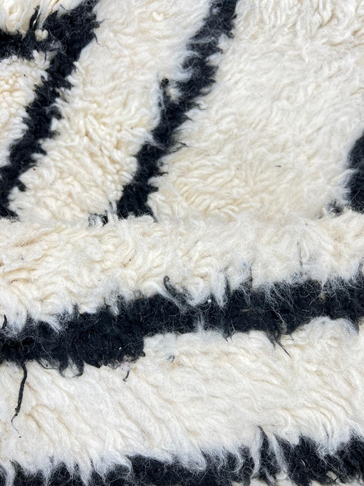 Black and white Moroccan wool runner rug with Beni Ourain diamond pattern and fringed edges