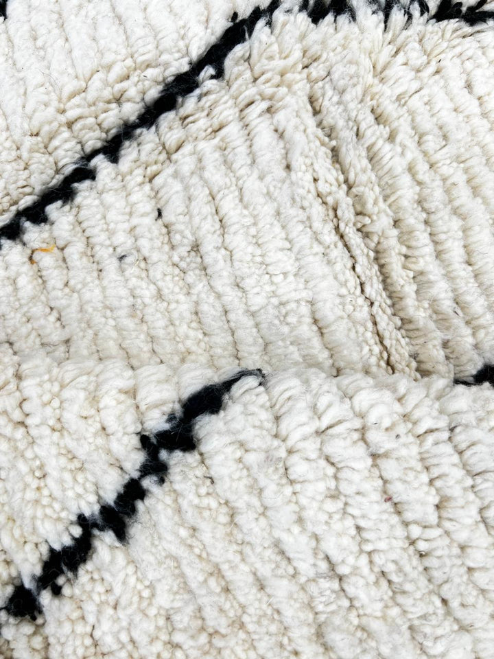 Handmade black and white Moroccan runner rug with minimalist Berber symbols and white wool base