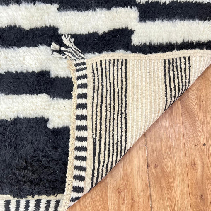 Minimalist Moroccan rug in black and white wool with geometric pattern