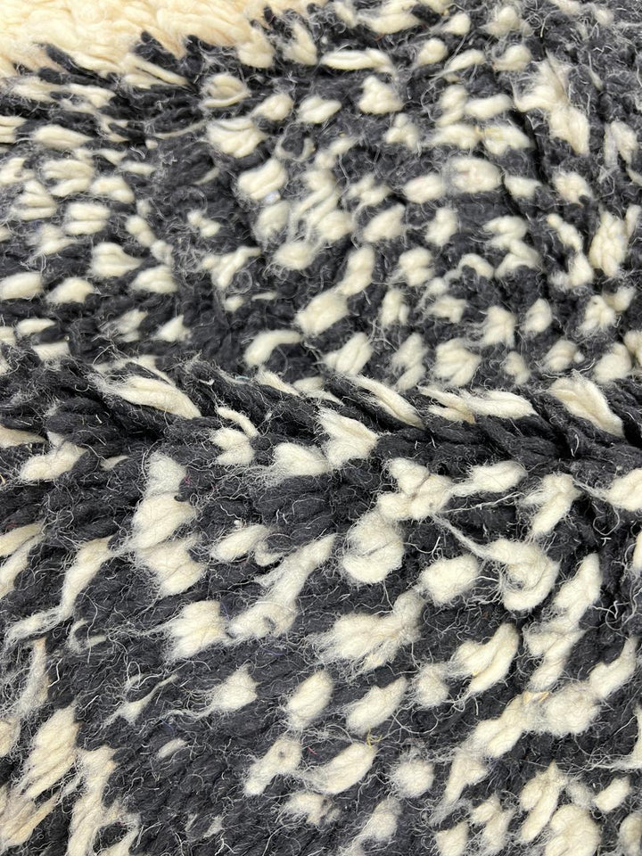 Handmade Moroccan wool rug with abstract black, cream, and red geometric design