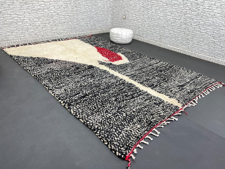 Handmade Moroccan wool rug with abstract black, cream, and red geometric design