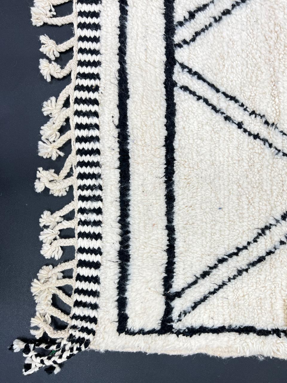 Black and white handmade Beni Ourain Moroccan wool rug with geometric diamond design and fringed edges