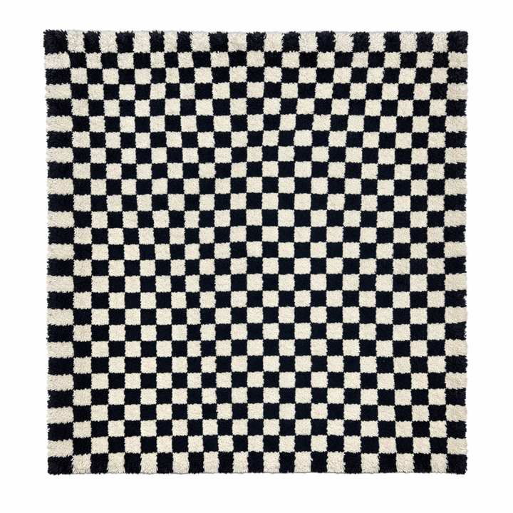 Handmade Moroccan wool rug with black and white checkered design. Plush shag texture, modern style, and artisan crafted.