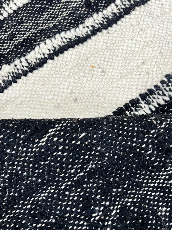 Black and white Moroccan wool rug with vertical stripe design, handmade by Berber artisans