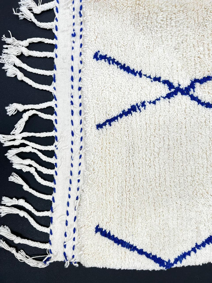 Blue diamond Moroccan runner rug made of natural wool with minimalist Berber pattern on white background and fringed edges