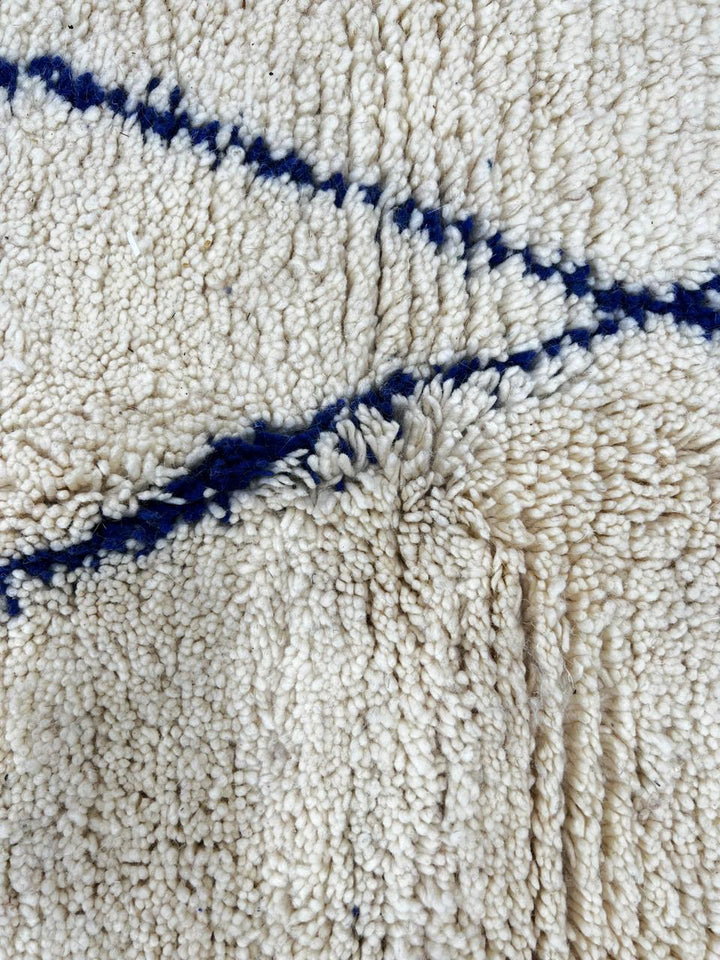 Blue diamond Moroccan runner rug made of natural wool with minimalist Berber pattern on white background and fringed edges