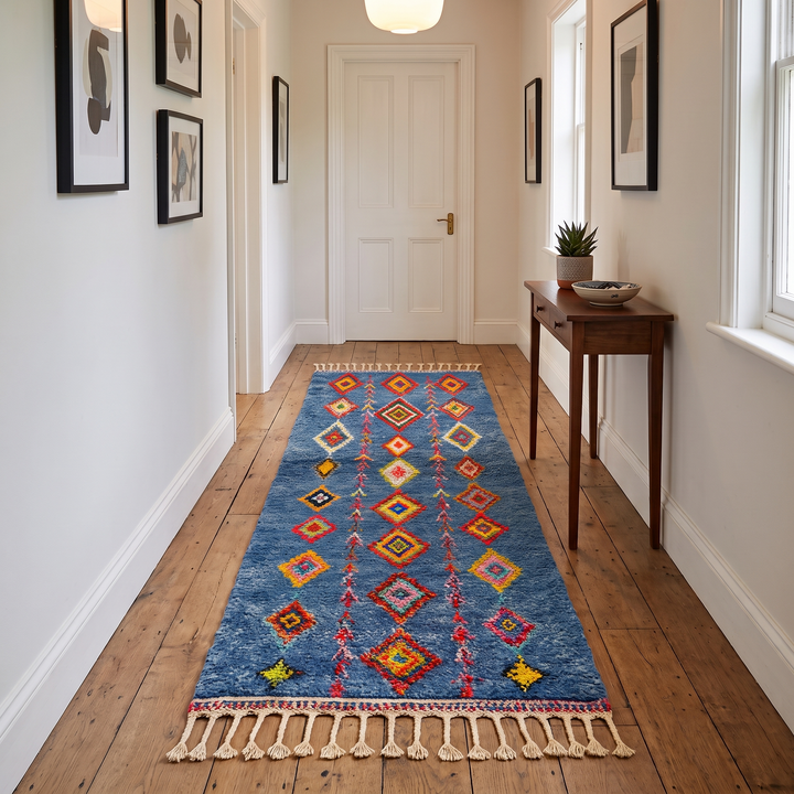 Handmade blue Moroccan runner rug with colorful Berber diamond motifs, crafted from natural wool in a traditional geometric design.