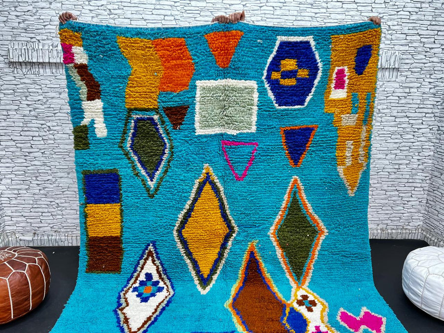 Handwoven blue Moroccan wool rug with colorful geometric Berber motifs